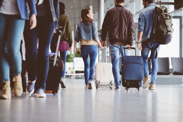 a group of people wheeling luggage in an airport