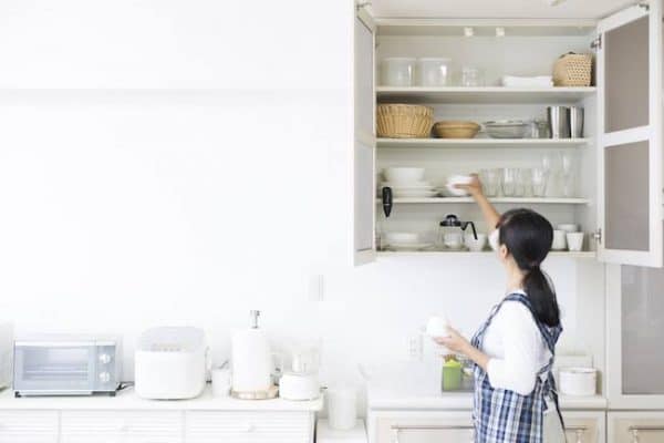 a woman arranging her tableware on the shelf