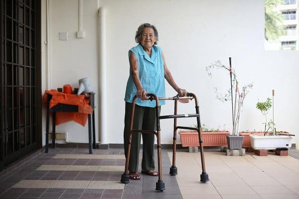 an elderly woman walking with a walking aid