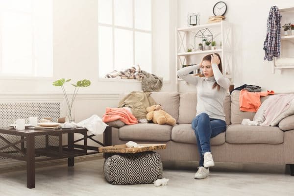 a woman stressed over her clutter while sitting on her sofa