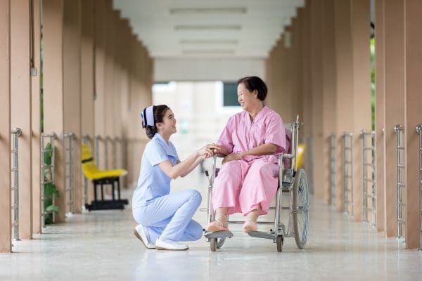 a nurse taking care of an elderly woman in a wheelchair