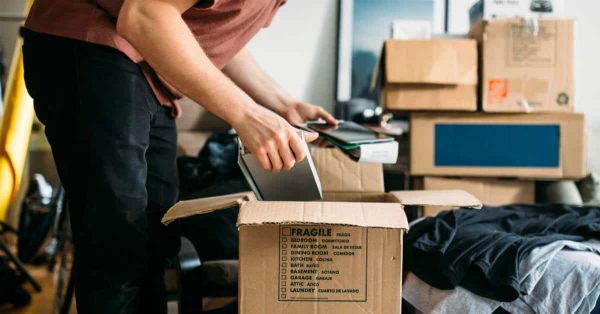 a man packing his things inside a box