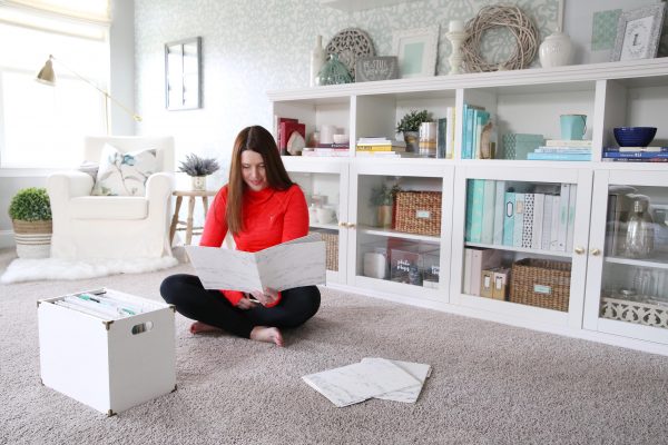 a woman looking at a photo album as she organizes her living space