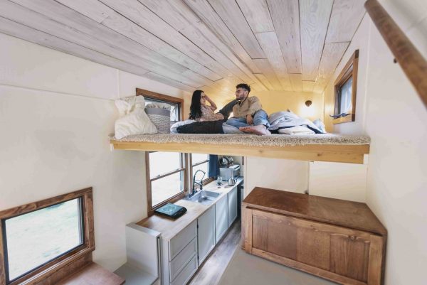 a couple resting on their loft bed