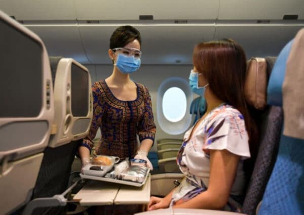 A flight attendant tending to a passenger on the plane