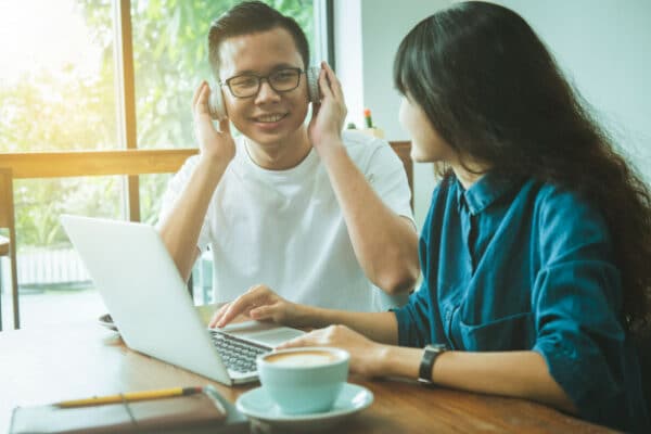 an asian man listening to music with his headphones