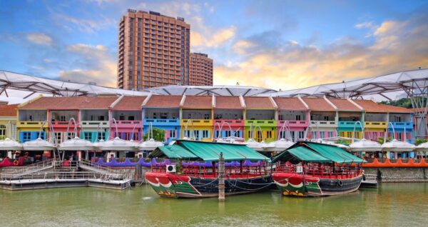 River taxis parked near the deck of a colorful street in Singapore