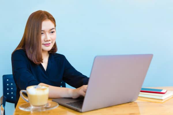 an asian woman happily working on her desk