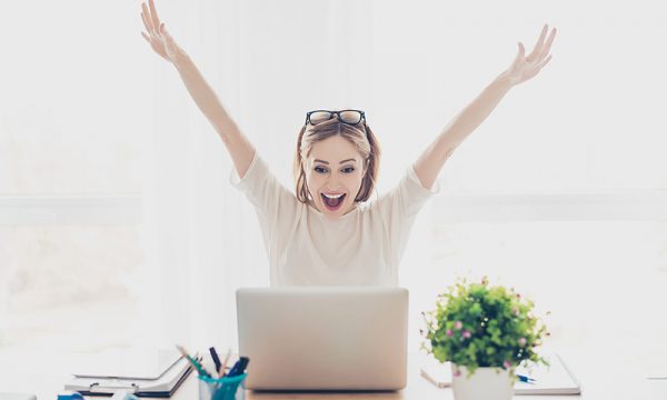 a woman screaming joy and throwing her hands up