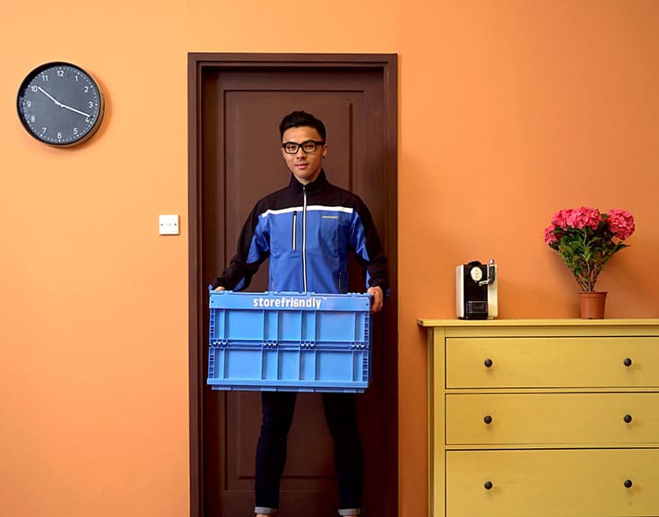 Man lifting a blue crate