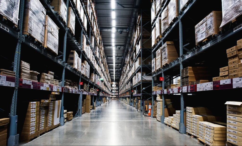 Spacious and organised storage space for rent with high shelving units and secure storage areas.